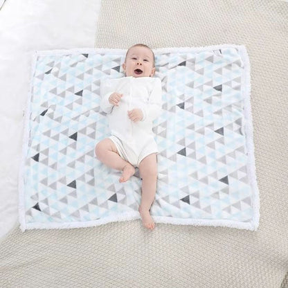 bebe allonge sur couverture bebe motifs géométriques