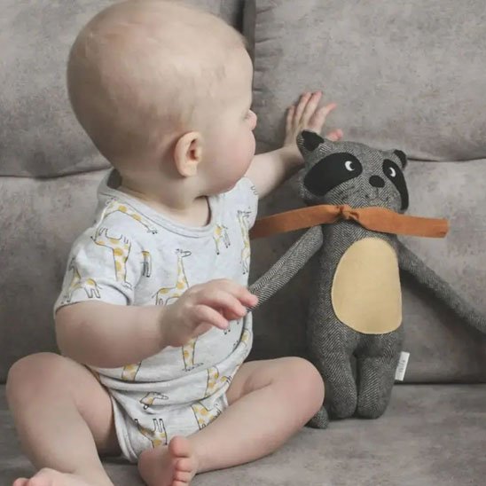 bébé assis avec doudou renard gris noir