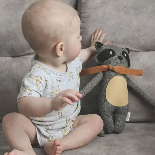 bébé assis avec doudou renard gris noir