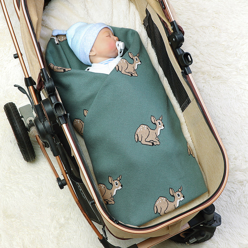 bébé  dans poussette avec couverture bébé verte