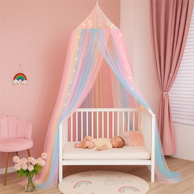 bébé dort sous ciel de lit multicolore