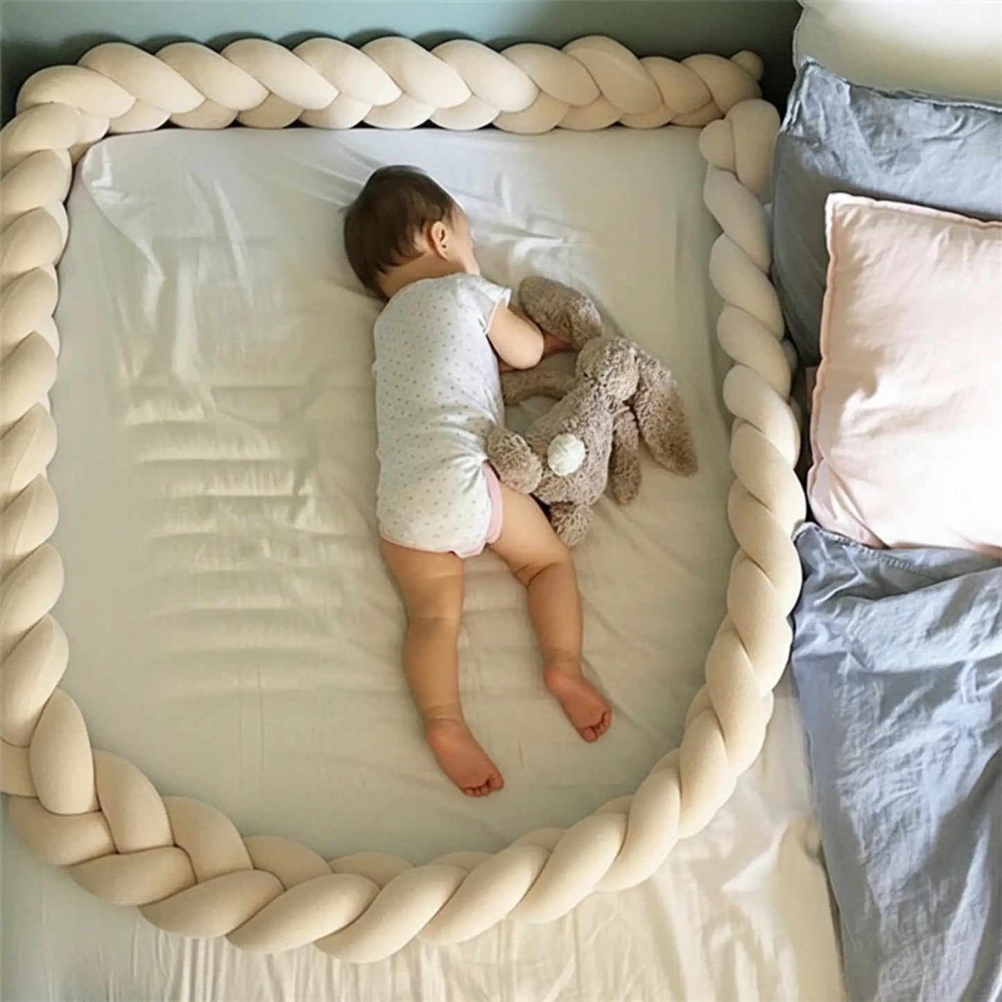 bebe dort sur le ventre dans lit avec tresse de lit bebe beige