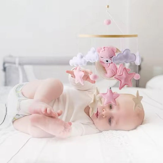bébé joue avec mobile lit bébé bois ours