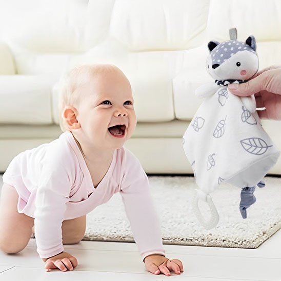 bébé souriant joue avec doudou renard