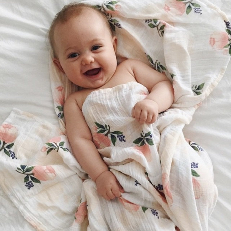 bébé  souriant sous couverture bébé