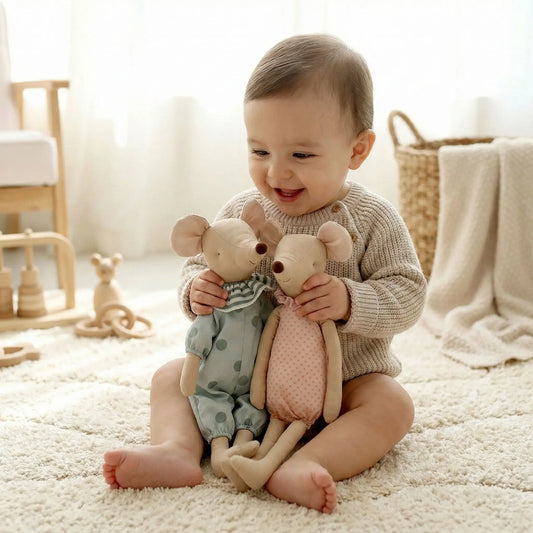 bébé souriant tient aux mains doudou scandinave