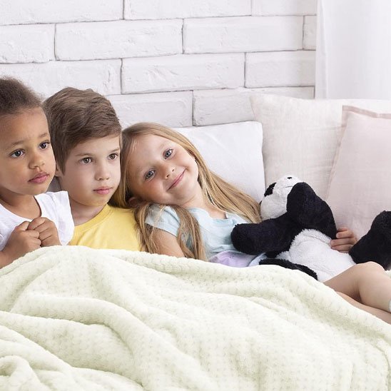 couverture bebe blanc ivoire couvre trois enfants sur sofa