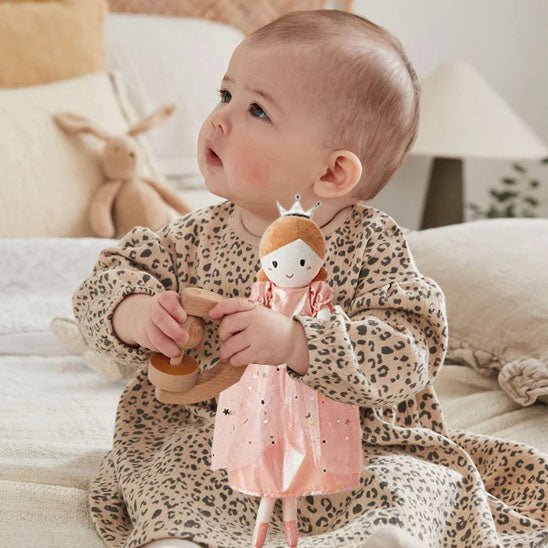doudou princesse  enchantee en robe rose dans bras bebe fille