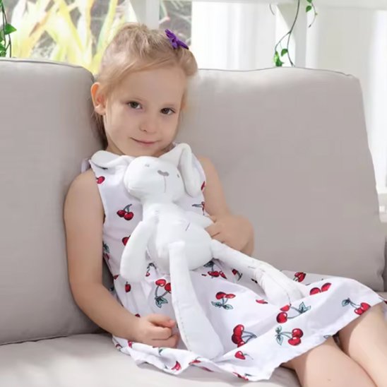 fillette assise avec doudou bébé lapin blanc