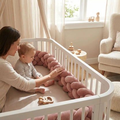 maman reconforte bebe en touchant tresse de lit bebe vieux rose