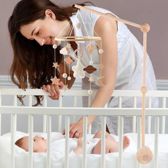 maman regarde bébé dans lit avec mobile bébé ciel étoilé