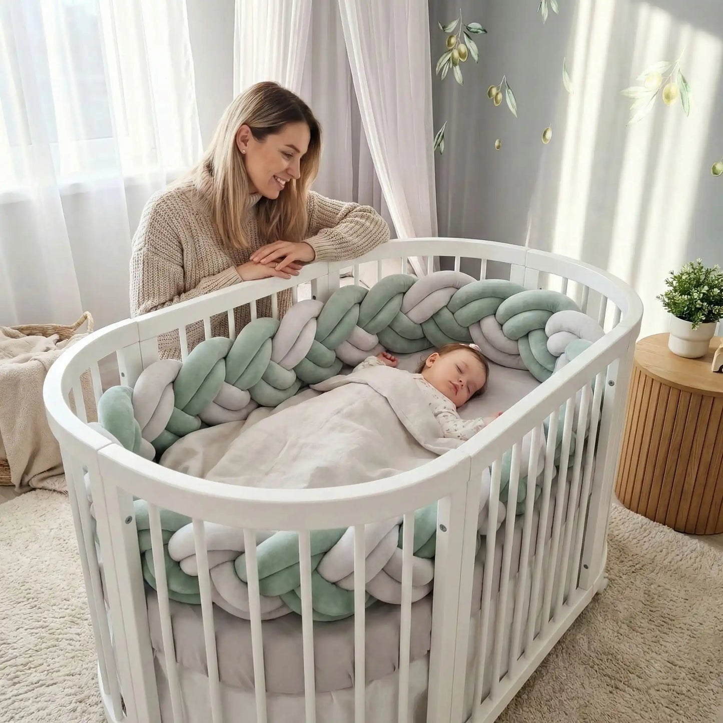 maman souriante observe bebe endormi lit garni tresse de lit vert blanc