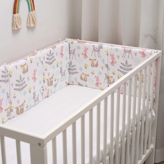 tour de lit bébé pastel dans lit blanc